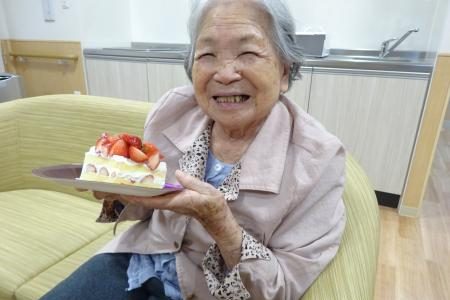 イメージ：ホールケーキと花束で誕生日のお祝い